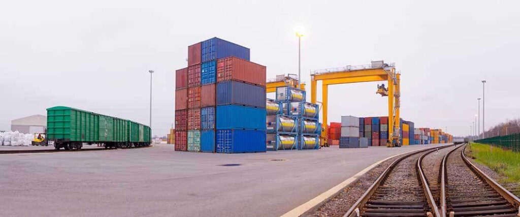 Stacked cargo containers by a railway