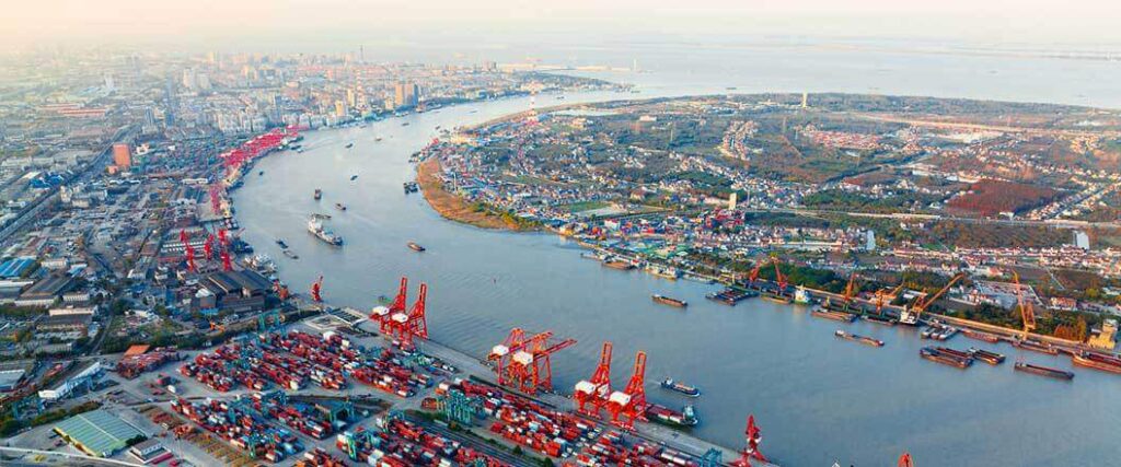 An aerial view of a port located along a busy river