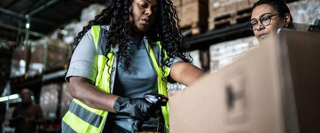 A warehouse worker scanning the barcode on a box