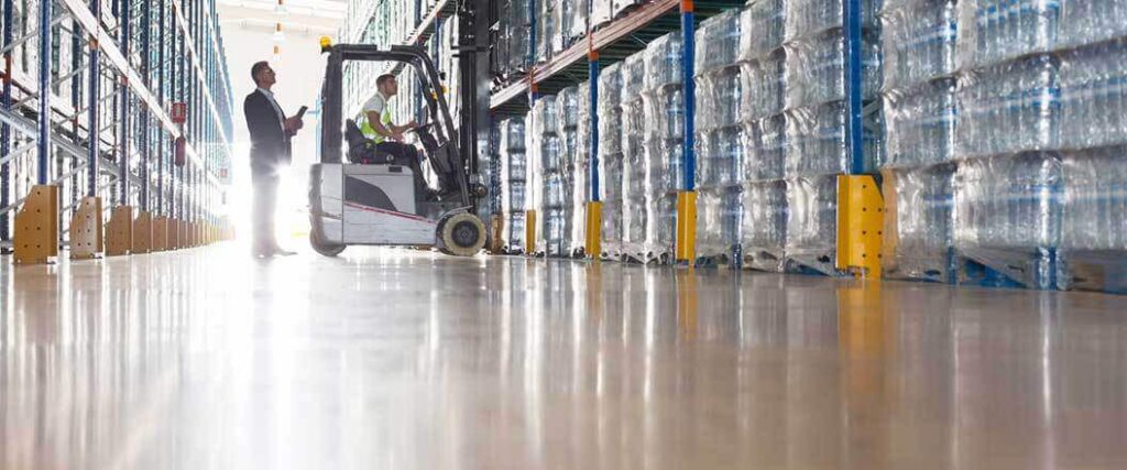 schedule b vs hs code worker on forklift in a warehouse with supervisor behind him
