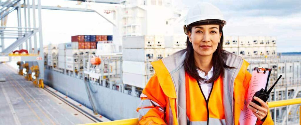 A port worker in front of a cargo ship